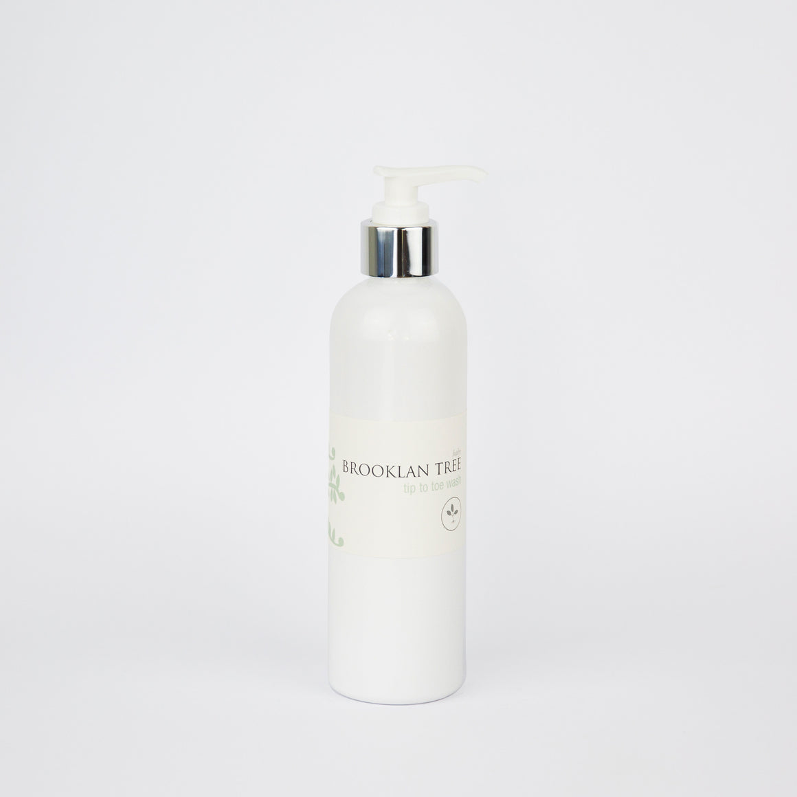 bottle only with natural looking green leaves on a very pale light green background 